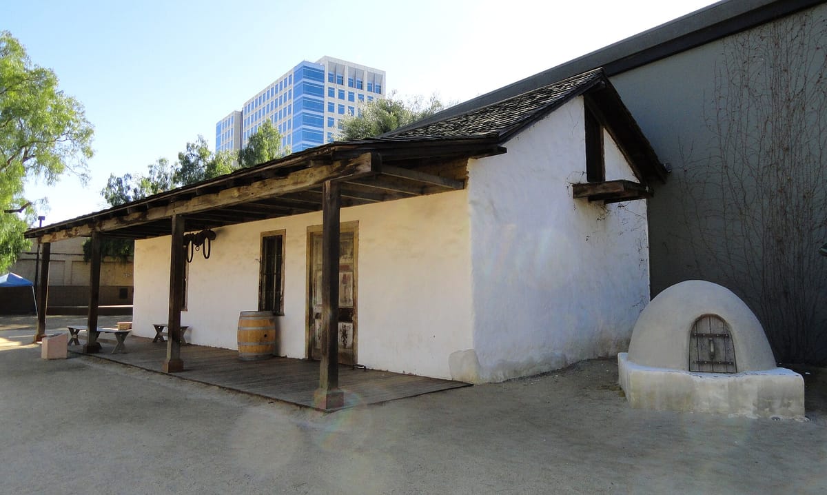 The whitewashed walls and tile roof of the Peralta Adobe, built about 1797